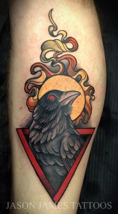 a black bird sitting on top of a red triangle