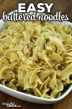 a white bowl filled with pasta and sauce on top of a wooden table next to the words easy buttered noodles