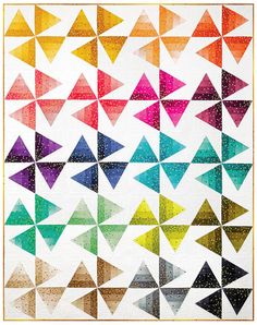 a colorful quilt with lots of different colored triangles on the front and back of it