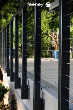 the side of a building with black metal bars on it and trees in the background