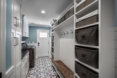 a walk - in closet with lots of drawers and baskets on the shelves next to it