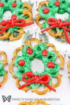 christmas pretzels decorated with green and red icing on a white tablecloth