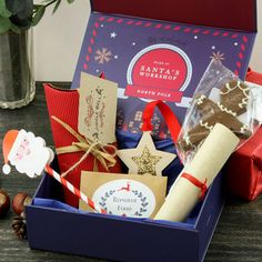 a gift box filled with cookies, crackers and other items next to a potted plant