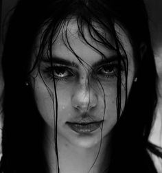 a black and white photo of a woman with wet hair