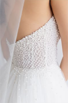 the back of a wedding dress with pearls on it