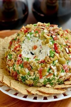 a white plate topped with lots of food on top of tortilla chips next to wine glasses