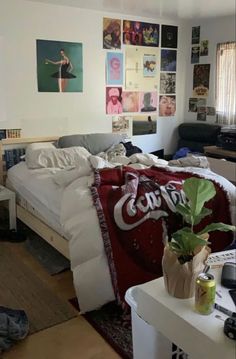 a bedroom with coca - cola posters on the wall and a bed covered in blankets