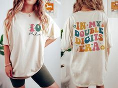 Celebrate a special milestone with our "In My Double Digits Era T-Shirt." Perfect for a 10th birthday, this shirt is a fun and stylish choice for a girl's birthday party. Product Features: + Milestone Design: "In My Double Digits Era" theme celebrates turning 10. + Personalized Gift: Customize with the birthday girl's name for a unique touch. + Birthday Party Tee: Ideal for 10th birthday celebrations. Make her 10th birthday unforgettable with this personalized t-shirt, a perfect gift for any 10-year-old girl. * Unisex T Shirt - 5.3oz 100% cotton; Ash Grey 99% cotton, 1% polyester - Sport Grey is 90% cotton & 10% polyester; Dark Heather is 50% cotton & 50% polyester. - Heavyweight classic unisex tee - Taped neck and shoulders; Tearaway label - Made with sustainably and fairly grown USA cott Double Digits Era, 10 Yrs Old Birthday Girls Party Ideas, In My Double Digits Era, Girl 10th Birthday Party Ideas, 10th Birthday Party Ideas, 10th Birthday Girl, 10th Birthday Shirt, 10th Birthday Party, Tenth Birthday