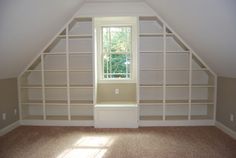 an empty room with some shelves in the corner and a window on the far wall