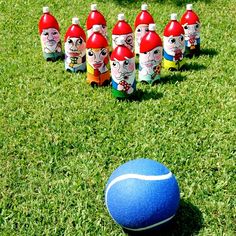 a blue ball sitting on top of a lush green field next to plastic water bottles