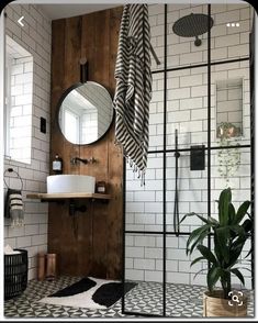 a bathroom with purple walls and black and white tiles on the floor, along with potted plants