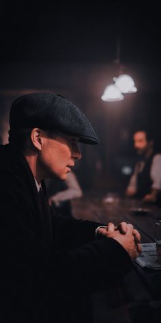 a man sitting at a table writing on a piece of paper