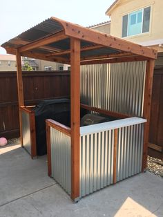 an outdoor hot tub in the middle of a yard with a wooden pergolan roof