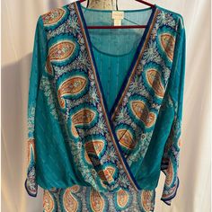 Very Unique Blouse, Reminds Me Of A Peacock. With Some Shimmer Never Worn Size 2 Chicos Teal Blue, Orange, White Blue Boho Print V-neck Top, Blue Bohemian Tops With Paisley Print, Bohemian Blue Tops With Paisley Print, Blue Paisley Print Bohemian Tops, Bohemian Blue Paisley Print Tops, Blue Paisley Print Summer Blouse, Blue Vibrant Print Vacation Blouse, Blue Paisley Print Top For Vacation, Blue Long Sleeve Blouse With Vibrant Print