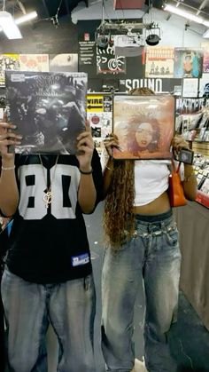 two women holding up records in front of their faces