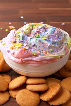 a bowl filled with cake and sprinkles next to crackers