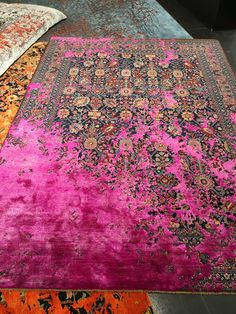 two rugs with different colors and patterns are on the floor next to each other