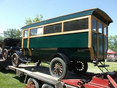 an old timey car is on the back of a trailer