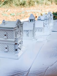 a row of white houses sitting on top of a table