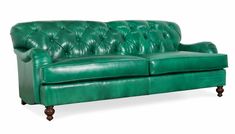 a green leather couch sitting on top of a white floor