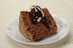 a piece of cake on a white plate with chocolate drizzle