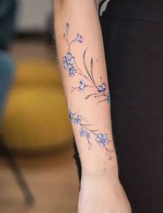 a woman's arm with blue flowers on it