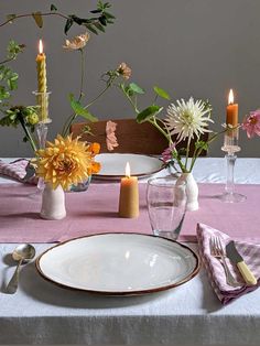 the table is set with flowers and candles