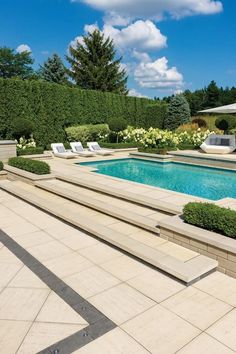 an outdoor swimming pool with steps leading up to it and trees in the back ground