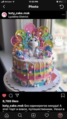 the cake is decorated with unicorns and balloons