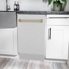 a kitchen with white cabinets and black counter tops, gold hardware on the door handles