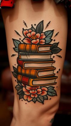 a woman's thigh with books and flowers on it