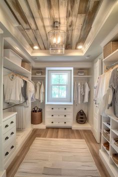 an organized walk in closet with white cabinets and drawers, wood plank ceilinging, and open shelving