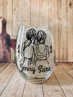 personalized wine glass with two women hugging each other on the bottom and name in black ink