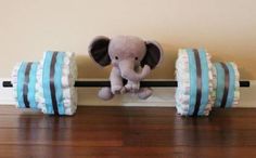 an elephant stuffed animal sitting on top of two rolls of diapers in front of a wall