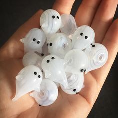 a hand holding a bunch of white plastic ghost beads