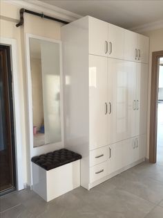 an empty room with white cabinets and mirrors