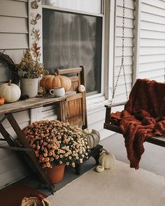 a porch with pumpkins and other fall decorations