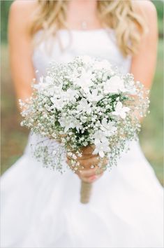 a bride holding a bouquet of white flowers