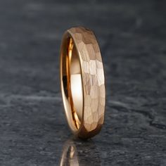 a gold wedding band with an intricate design