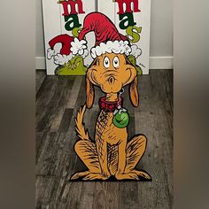 an image of a dog with a santa hat on it's head sitting in front of two christmas signs