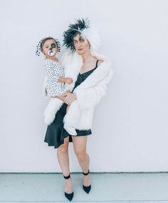 a woman and child dressed up in animal print outfits, posing for the camera with their arms around each other