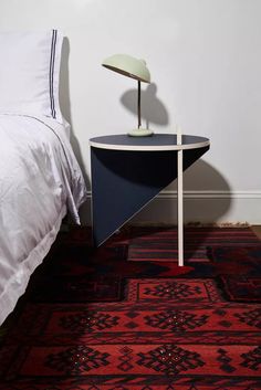 a bedroom with a bed, rug and lamp on the side table next to it