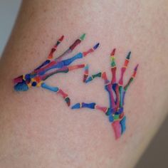 a colorful tattoo on the leg of a woman's arm that has multiple colored sprinkles coming out of it