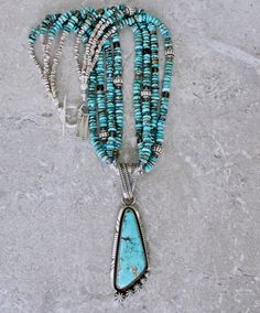 This eye-catching Necklace showcases a Kingman Turquoise and Sterling Silver Pendant by Navajo Jewelry Artist Nila Cook Johnson. Johnson is known for the exceptional quality of her work, and this piece is no exception. The triangular Pendant features a soft blue Kingman Turquoise stone, splashed with filaments of brown matrix. The stone is wrapped in a Sterling Silver Bezel and encircled by twisted Sterling Silver Wire, which has been oxidized for contrast. It sits on Sterling Silver Plate that Bohemian Blue Multi-stone Turquoise Necklace, Blue Multi-stone Bohemian Turquoise Necklace, Blue Multi-stone Round Beads Jewelry, Artisan Multi-stone Turquoise Necklace, Artisan Blue Multi-stone Turquoise Necklace, Artisan Blue Turquoise Multi-stone Necklace, Blue Multi-stone Turquoise Necklace For Jewelry Making, Turquoise Multi-stone Beaded Necklaces With Round Beads, Johnson Johnson