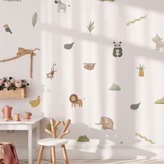 a child's room with various wall decals on the wall and a white table