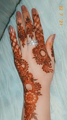 hendi tattoos on the palm of a woman's hand with her wedding ring