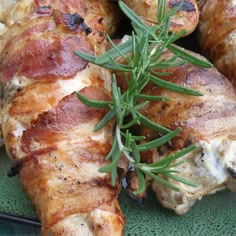 chicken legs with rosemary garnish on a green plate