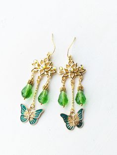 Delicate lotus flower earrings made with gold tone findings, enameled butterfly charms, glass beads and chrystal rhinestones.  Approximately 4 cm long. Bohemian Gold Butterfly Jewelry, Bohemian Green Butterfly Jewelry, Green Bohemian Butterfly Jewelry, Gold Butterfly Jewelry For Festival, Bohemian Gold Enamel Earrings, Festival Dangle Flower Earrings As Gift, Festival Gift Dangle Flower Earrings, Yoga Chakra, Earrings Golden