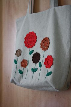 a white bag with crocheted flowers on it