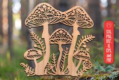 a wooden cutout of mushrooms in the woods with a red sticker on it